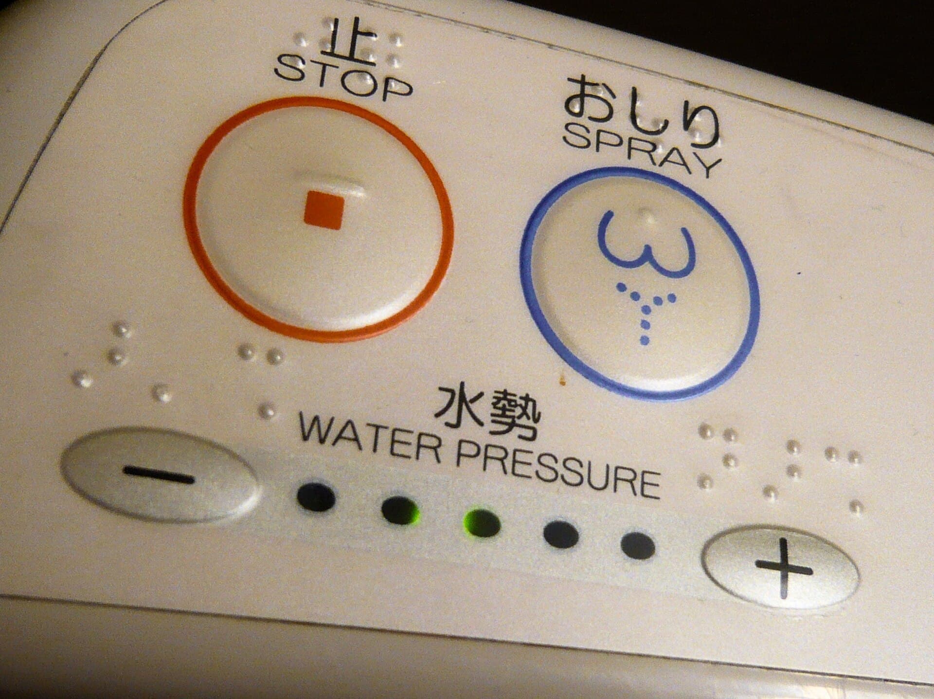 A wall-mounted control panel for a Japanese electronic bidet toilet
