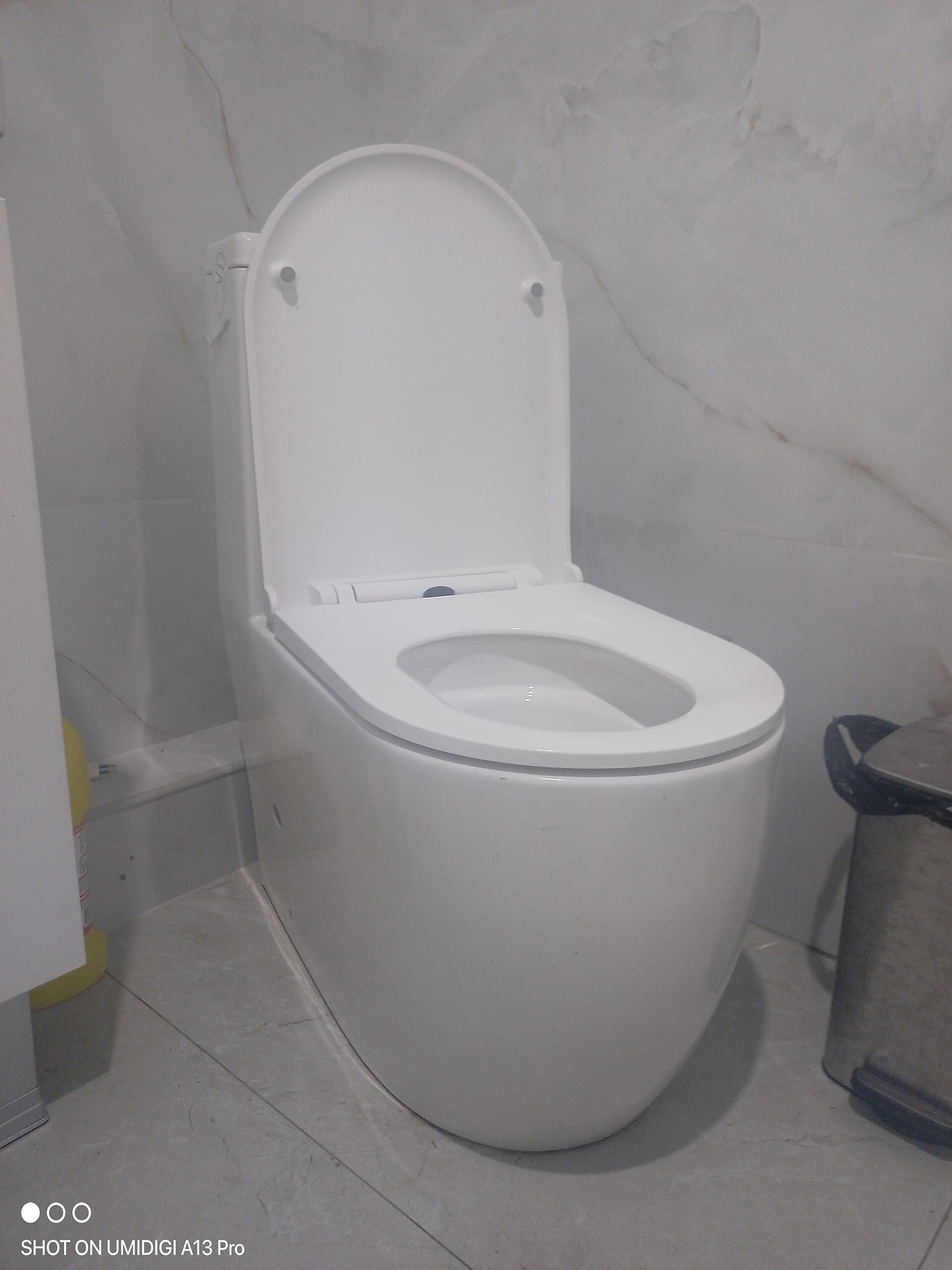 A close-coupled ceramic toilet with cistern and seat in a domestic bathroom
