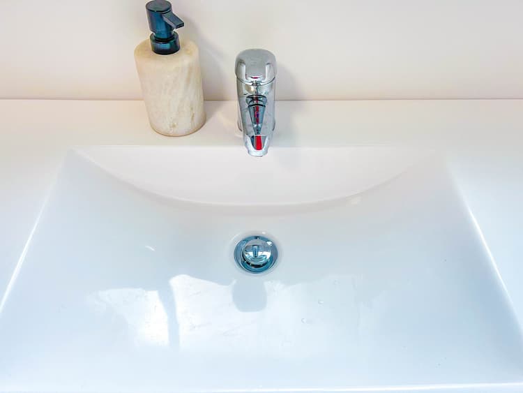 Chrome bathroom basin taps on a white ceramic sink